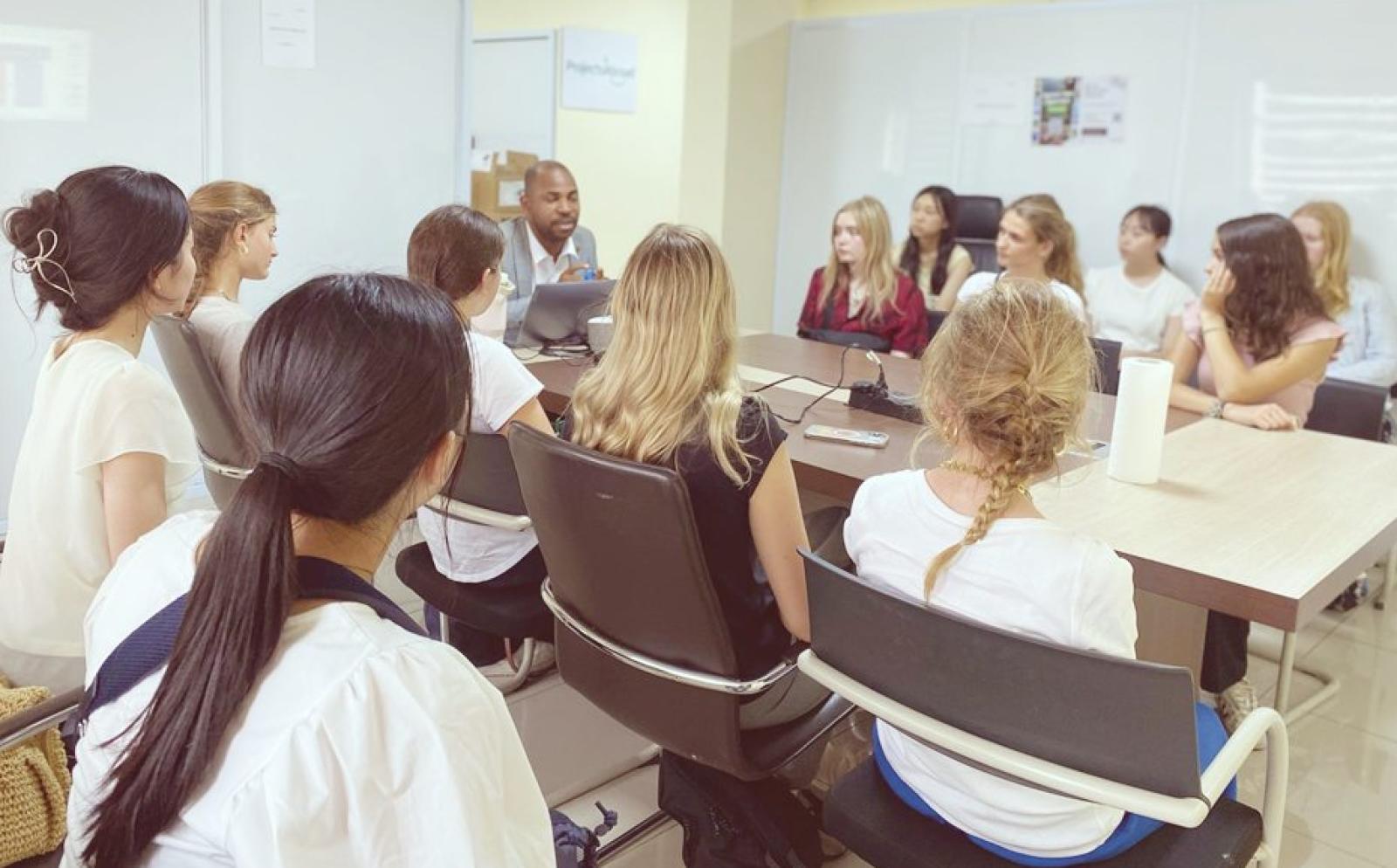 インターン学生がミーティングでマネージャーの話を聞く